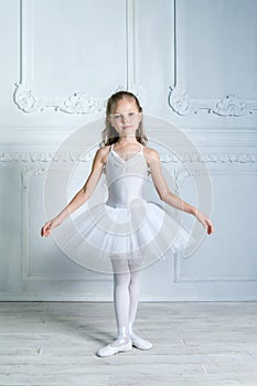 A little adorable young ballerina in a playful mood in the inter