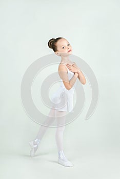 A little adorable young ballerina poses on camera