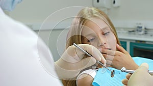 Little afraid girl at dentist office. Health and dental care. Closeup shot of dentist with drill and mirror in hands. 4K