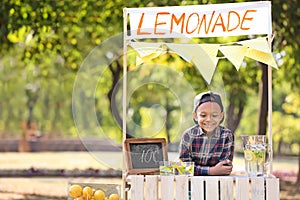 Little African-American boy at lemonade stand in park