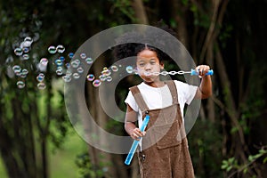 Little African American curly hair girl playing on park playground in spring or summer season. They enjoy climbing on the rope equ