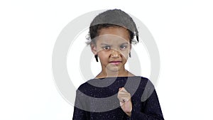 Little african american girl in an evil mood. White background. Slow motion