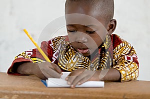 Little African Black Baby Boy in the Classroom Writing Notes