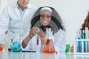 Little African black kids learning chemistry in school laboratory