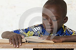 Little African Boy Reading Big Book at School with copy space