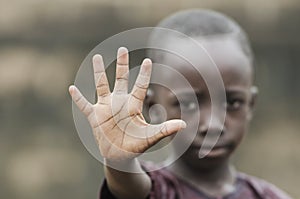 Little African boy showing Palm as STOP sign to racism, war and fight