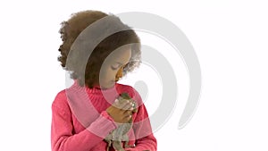 Little african curly girl is holding and stroking Bearded agama at white background. Slow motion