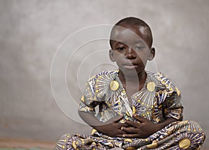 Little African cute Boy Looking Sadly with hands on belly desaturated