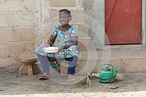 Little African Girl Cooking Rice Outdoors Smiling at Camera