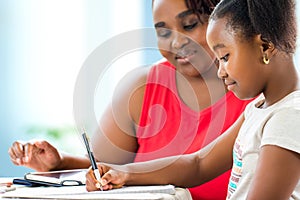 Little african girl doing home work with supervisor.