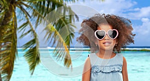 Little african girl in sunglasses on beach