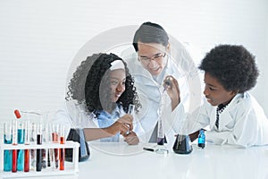 Little African kids learning chemistry and doing a chemical science experiment in a laboratory in school