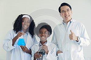 Little African kids learning chemistry and doing a chemical science experiment in a laboratory in school