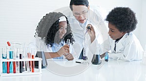 Little African kids studying chemistry and doing chemical science experiment in laboratory at school