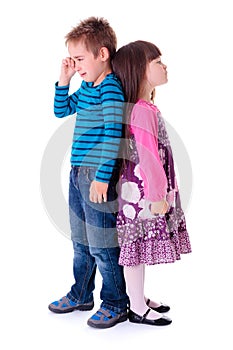 Little aggrieved boy standing near girlfriend