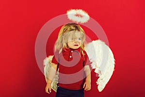 Little angel boy crying with white feather wings and halo