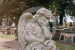 Little angel crying. Old stone statue. (concept children\'s mortality)