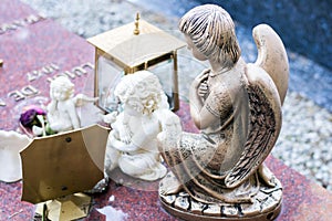 Little angels made from marble and bronze positioned on a grave