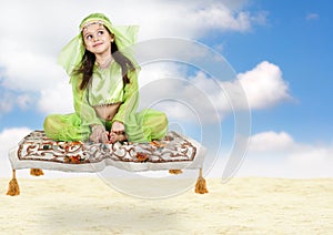 Little arabian girl sitting on flying carpet