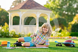 Little artist drawing painting art in park. Child artist, kids crafts. School kids drawing in summer park, painting art