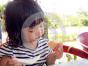 Little asia girl wakes up on the morning. She eating toast with strawberry jam. little asia girl has happy and good healthy when t