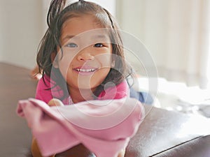 Little Asian baby girl being happy, with big smile, as she just successfully folded her own pants