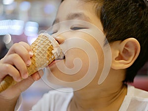 Little Asian baby girl enjoy eating ice cream cone