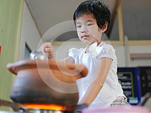 Little Asian baby girl enjoys cooking Thai-style hot pot