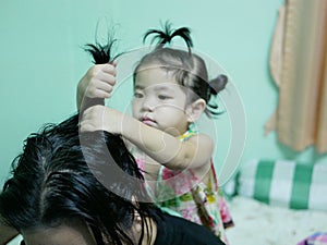 Little Asian baby girl giving her aunty`s hairs done