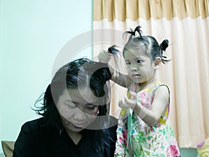 Little Asian baby girl giving her aunty`s hairs done