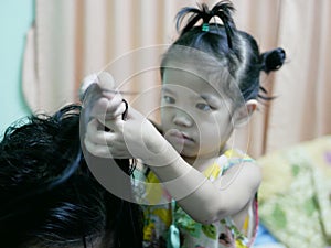 Little Asian baby girl giving her aunty`s hairs done