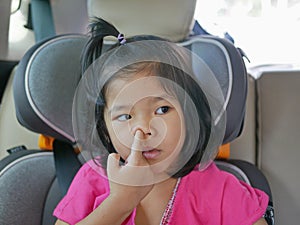 Little Asian baby girl picking her nose - child habit / behavior