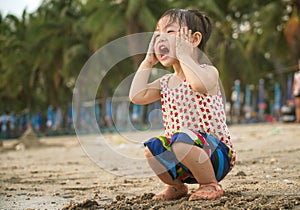Little asian baby girl playing sand on the beach