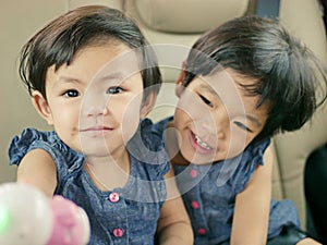 Little Asian baby girLittle Asian baby girl enjoying playing a dolla doll with her older sister