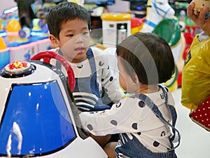 Little Asian baby refuses to let her baby sister play an arcade game together