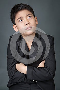 Little asian boy in black suit upset, depression face