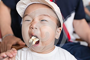 Little asian boy eating bread