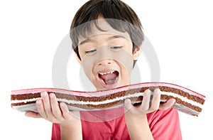 Little asian boy eating long cherry cake isolate on white background