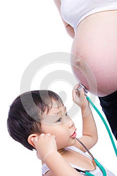 Little asian boy examining pregnant mother's tummy photo
