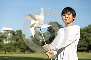 Little asian boy holding windmill or wind turbine mockup model. Gyre