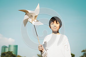 Little asian boy holding windmill or wind turbine mockup model. Gyre