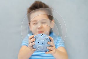 Little asian boy holds a piggy bank in his hands. money saving concept