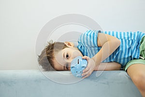 Little asian boy holds a piggy bank in his hands. money saving concept