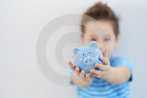 Little asian boy holds a piggy bank in his hands. money saving concept
