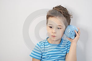 Little asian boy holds a piggy bank in his hands. money saving concept