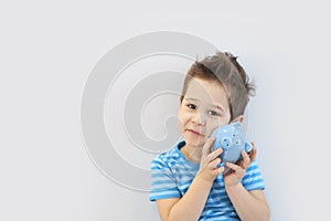 Little asian boy holds a piggy bank in his hands. money saving concept