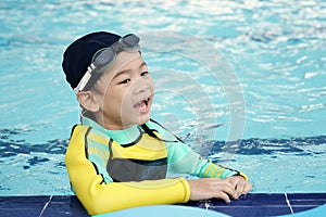 Little asian boy learn swimming in pool in activities time