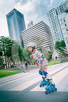 Little Boy is learning to Skate on an Rollerblade in park with full protection gear and helmet