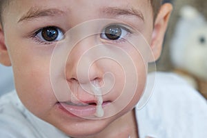 Little asian boy like picking a snot and eat snot and play snot in living room at home.