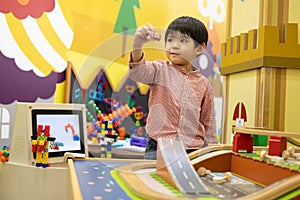 Little Asian boy playing with toy car in the children\'s play park